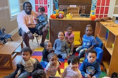 The executive director poses with kids from our blessings early learning center